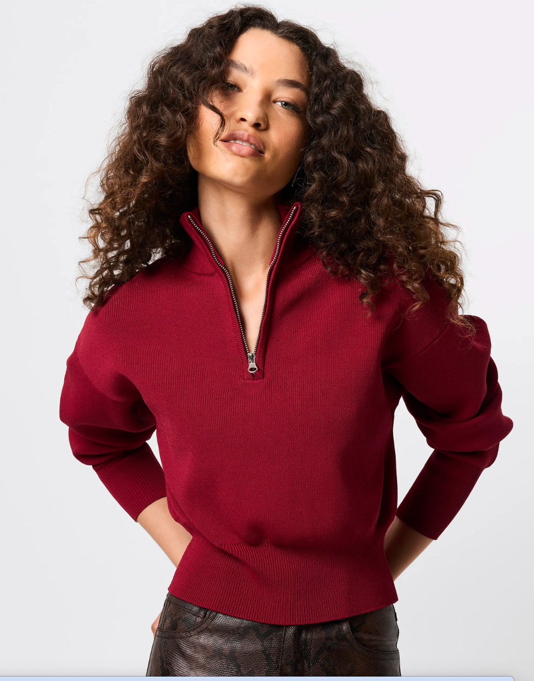 Woman wearing a red sweater with a zipper on a white background