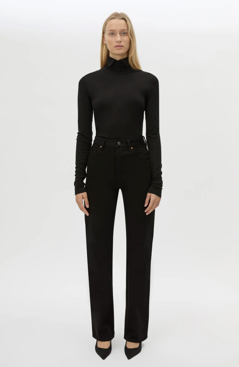 Person wearing a black turtleneck and black pants on a white background