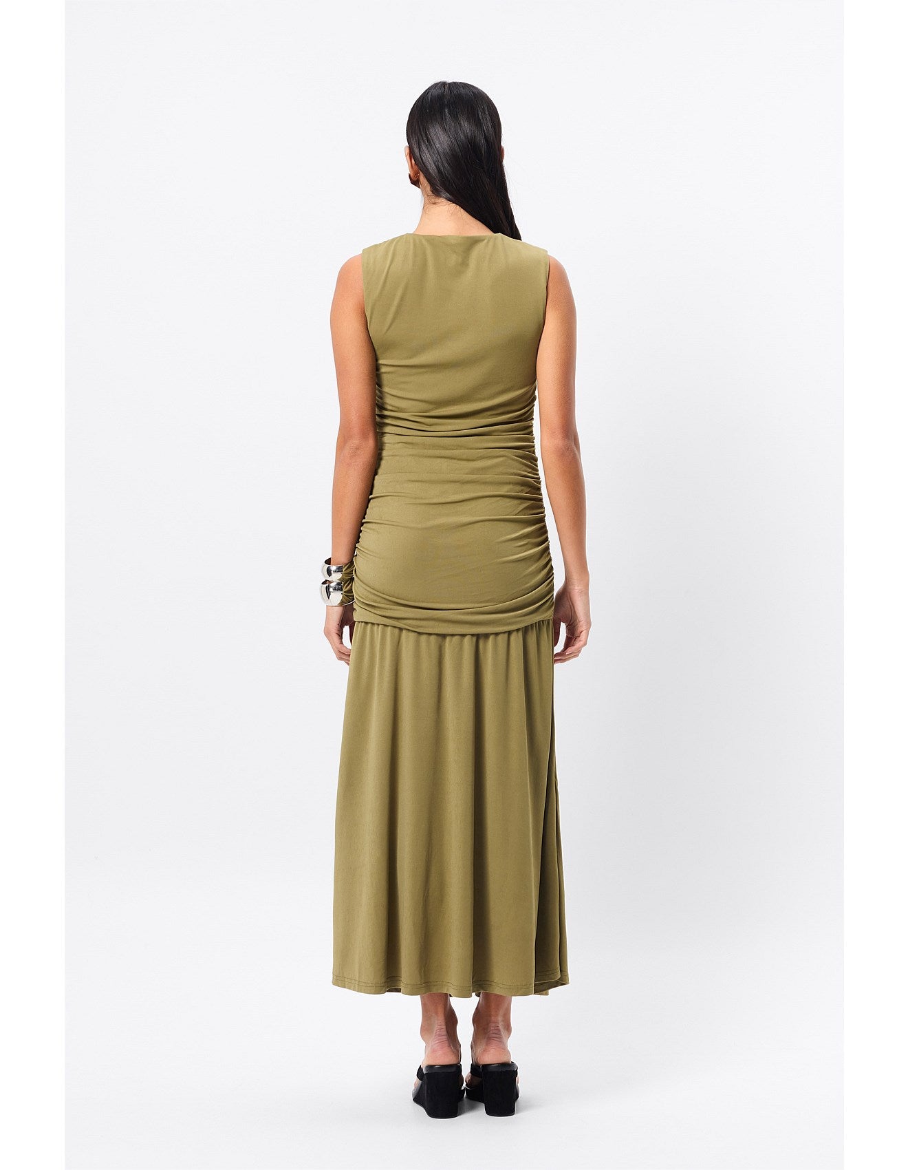 Woman standing in an olive dress for a special occasion.
Refined yet relaxed, the Sole Purpose Maxi Dress in Olive redefines everyday elegance. Designed in a soft stretch jersey fabrication, this sleeveless silhouette offers a round neckline and gathered detailing through the sides, sculpting the waist and hips for a flattering fit. The design falls to a gently flared maxi skirt, creating beautiful movement with every step. Body-lined for comfort, this dress is an effortless choice for both casual days and 