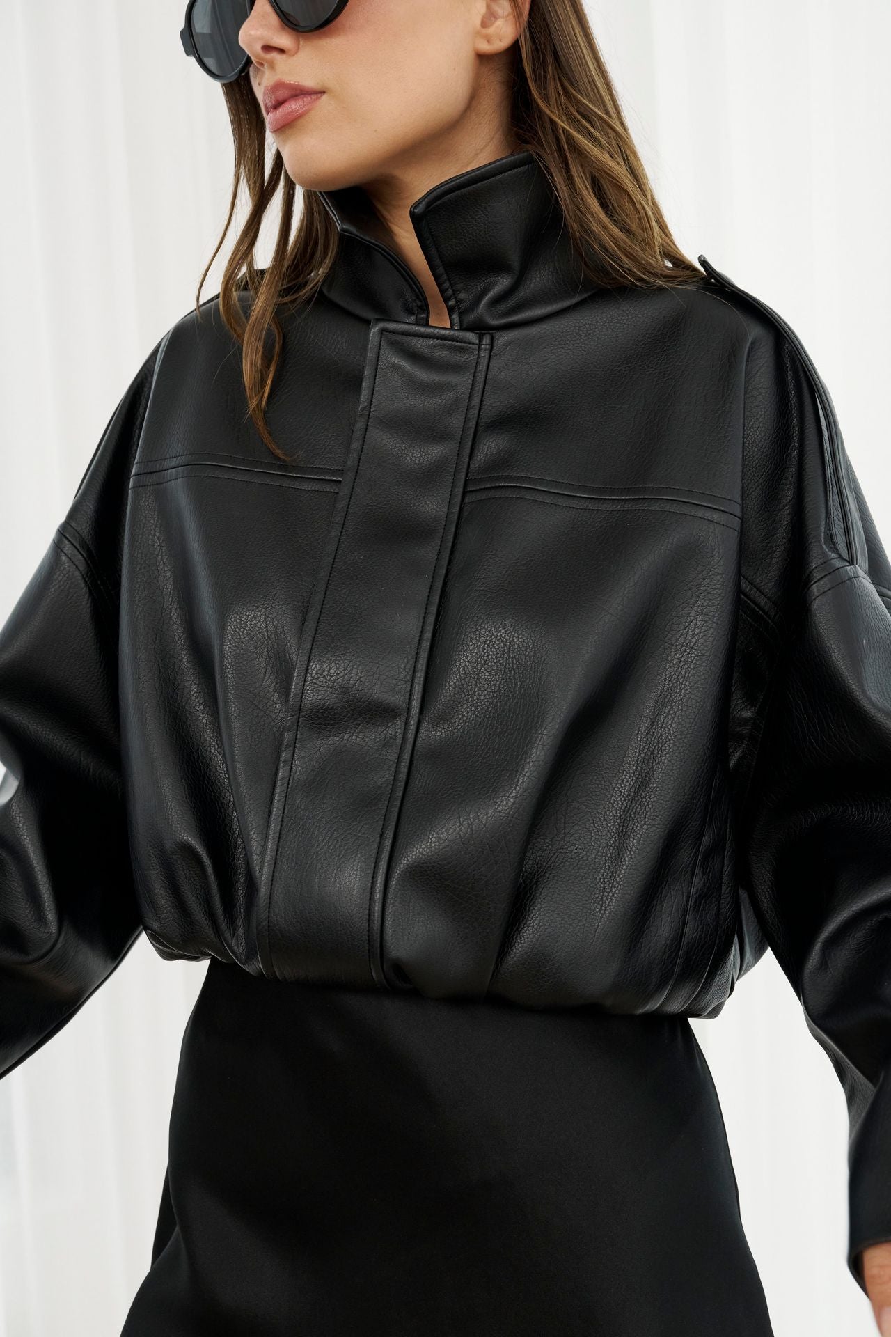 Person wearing a black leather jacket on a white background